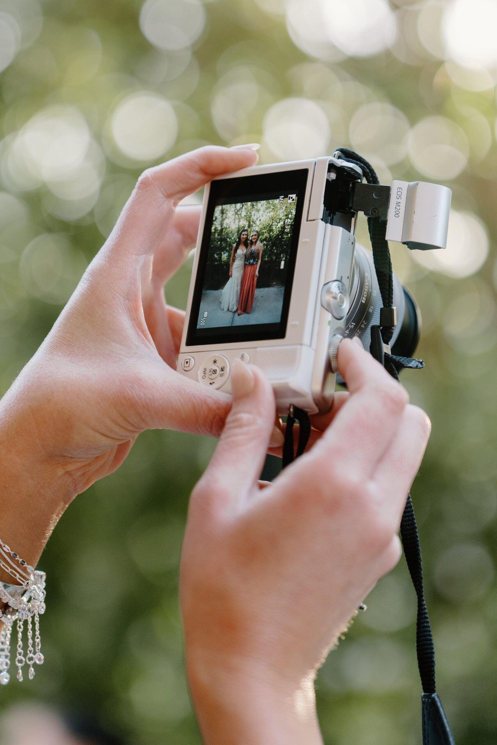 Close-up of a guest holding a small camera and capturing a portrait during the wedding day.