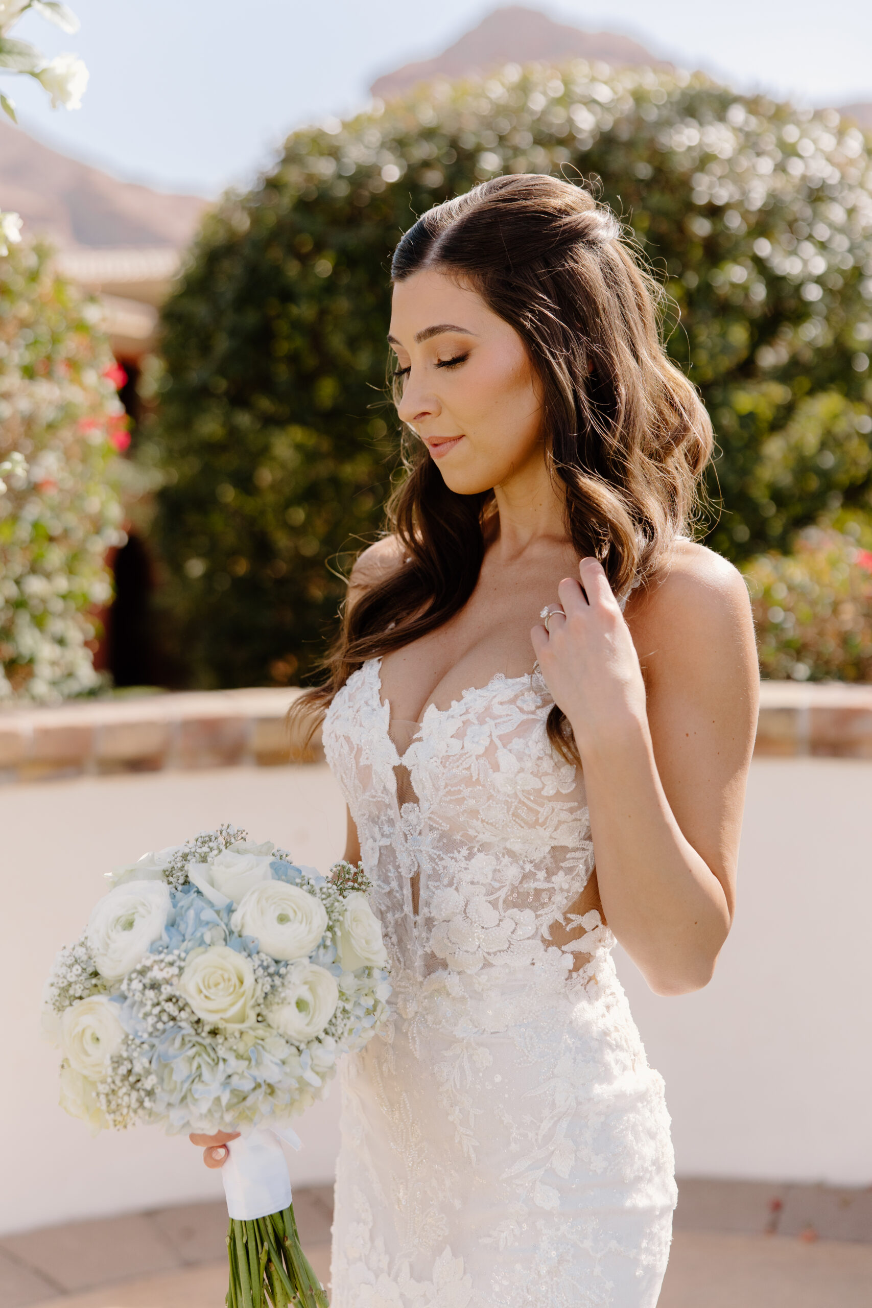 A stunning bridal portrait at Omni Montelucia, where the bride holds a bouquet of white and blue blooms in the soft Arizona sun.