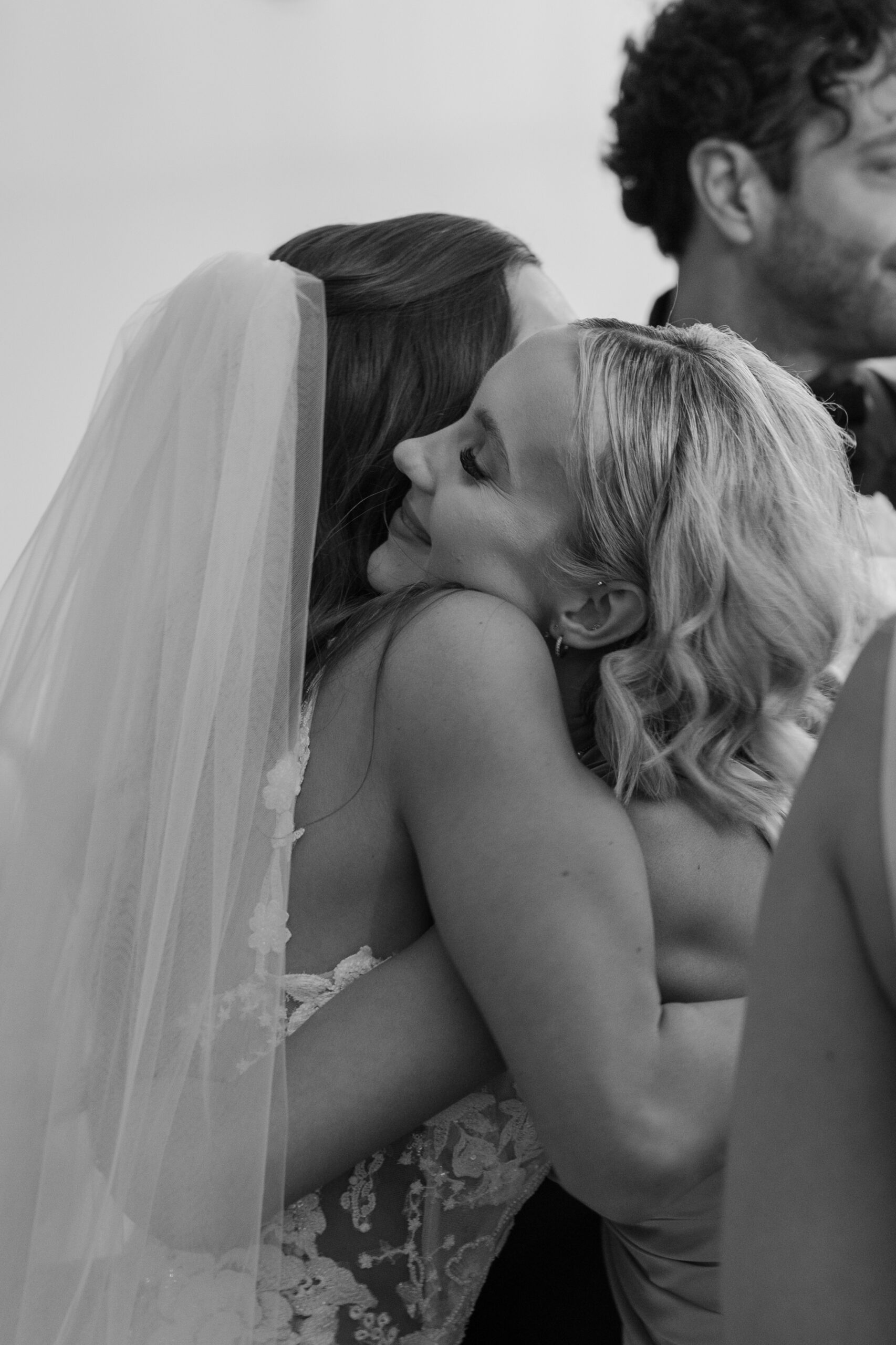A tender embrace between the bride and her bridesmaid at Omni Montelucia, captured in timeless black and white.