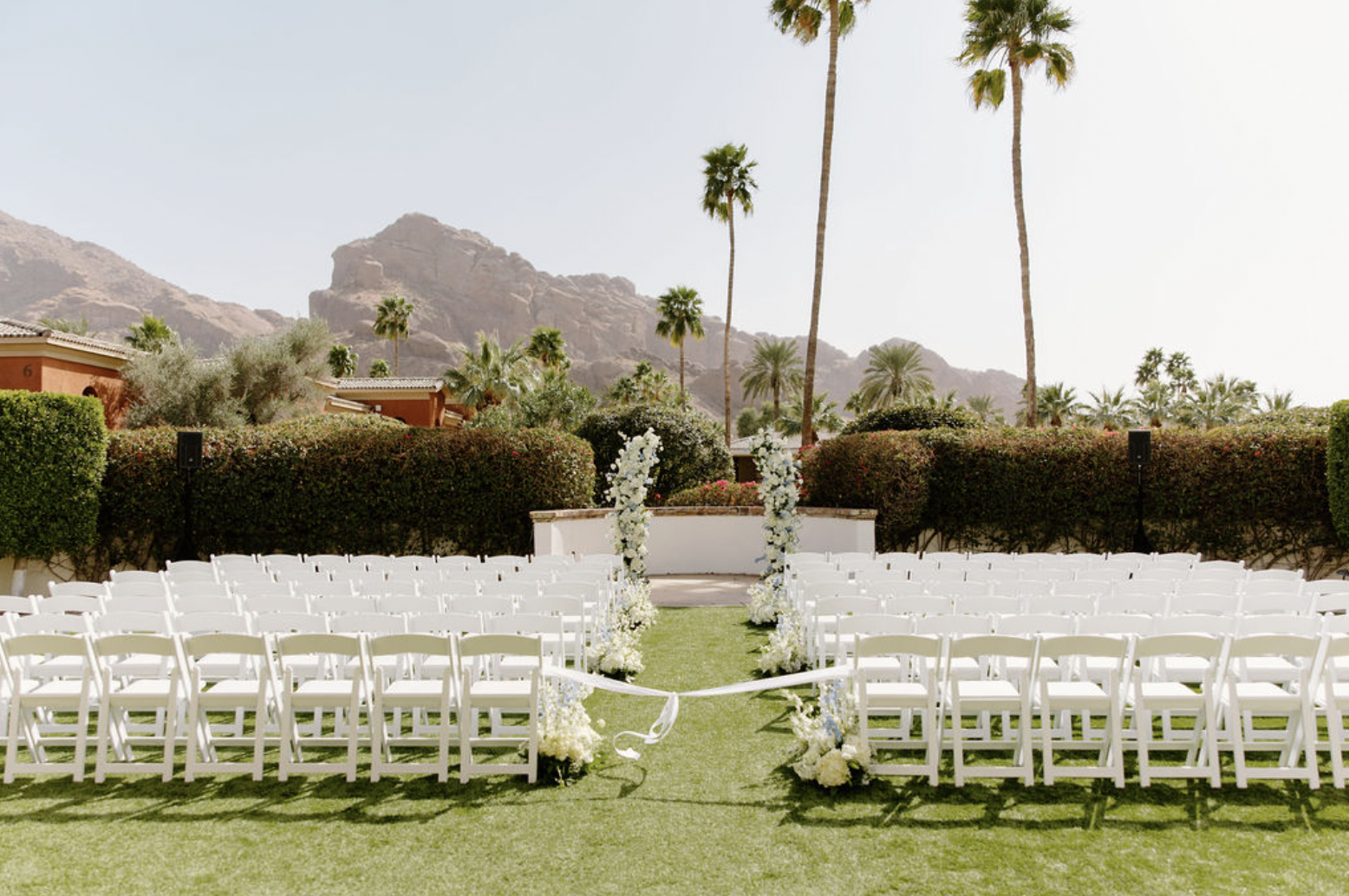 Ceremony chairs lined up on a sunny lawn with mountain views at the Omni Montelucia wedding venue.