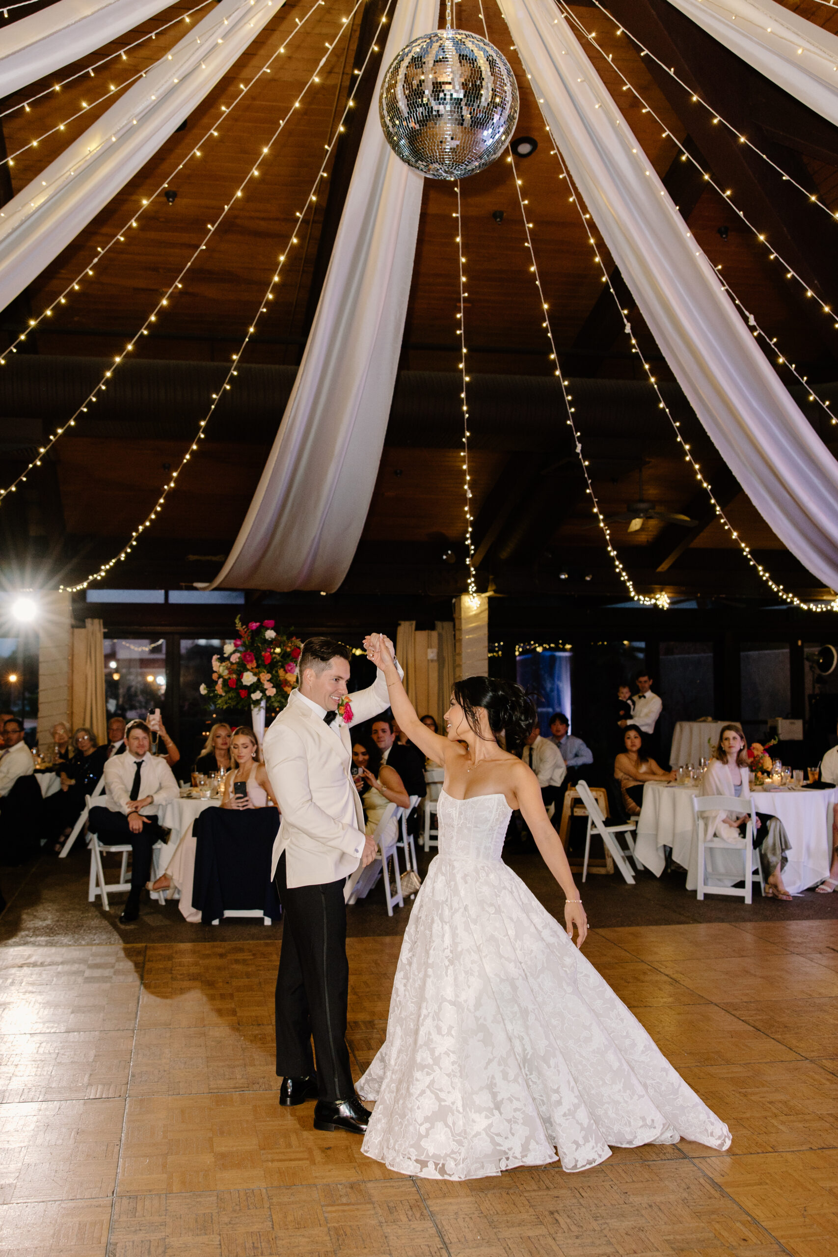 Bride and groom sharing their first dance under draped fabric and twinkle lights at McCormick Ranch Golf Club.