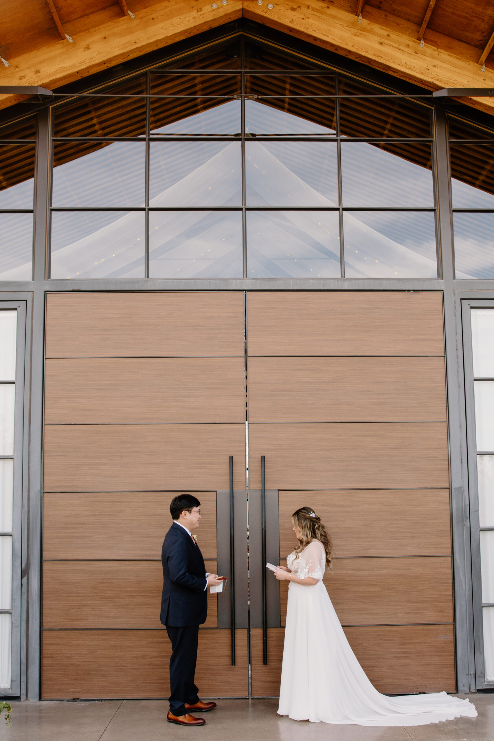 A wedding vow exchange framed by the wooden chapel structure and greenery at The Paseo, Arizona, where the desert backdrop meets modern design effortlessly.
