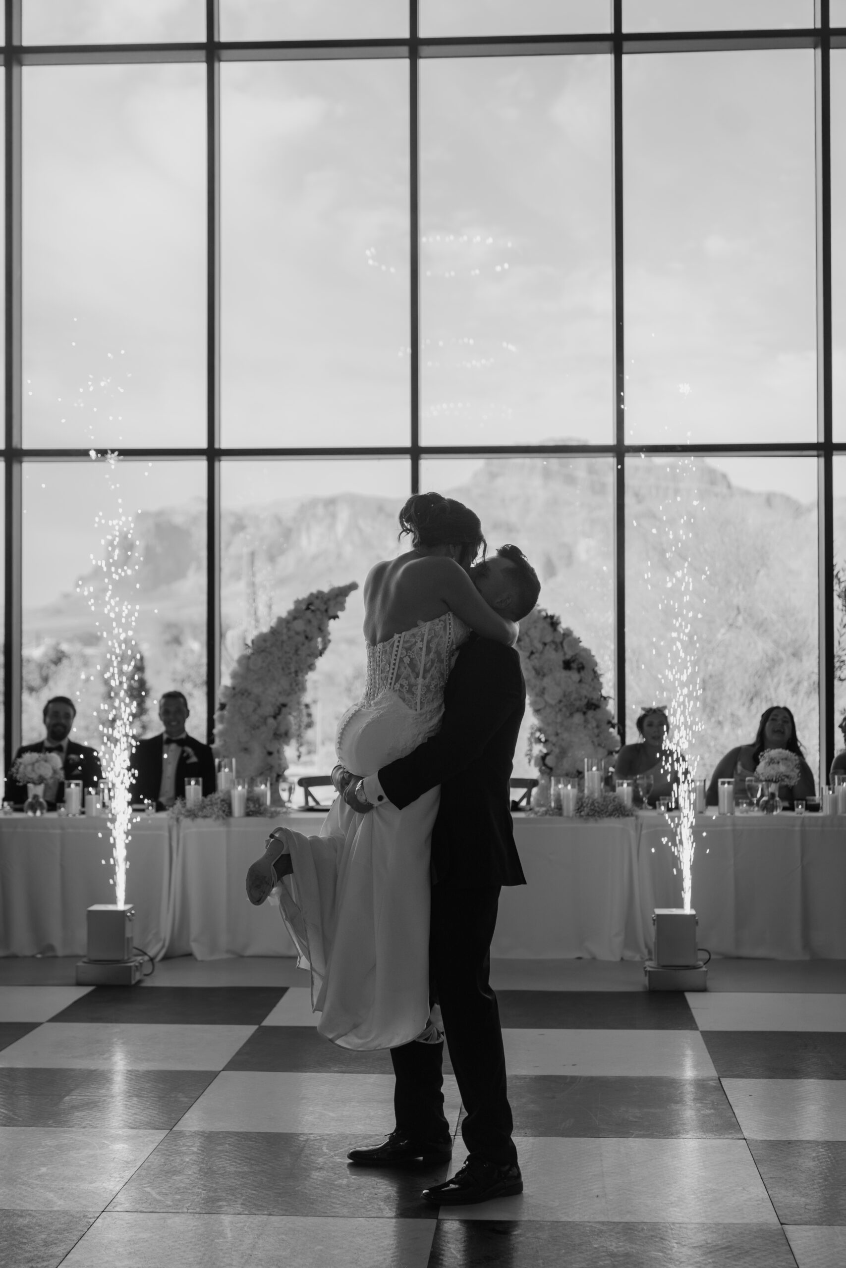 Bride and groom sharing their first dance inside the chapel with mountain views through floor-to-ceiling windows during their Desert View wedding reception.