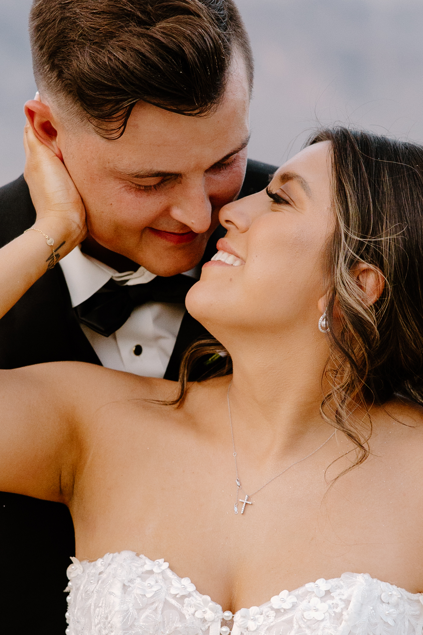 Close-up portrait of the bride and groom smiling with their faces close together during sunset portraits at their Desert View wedding.