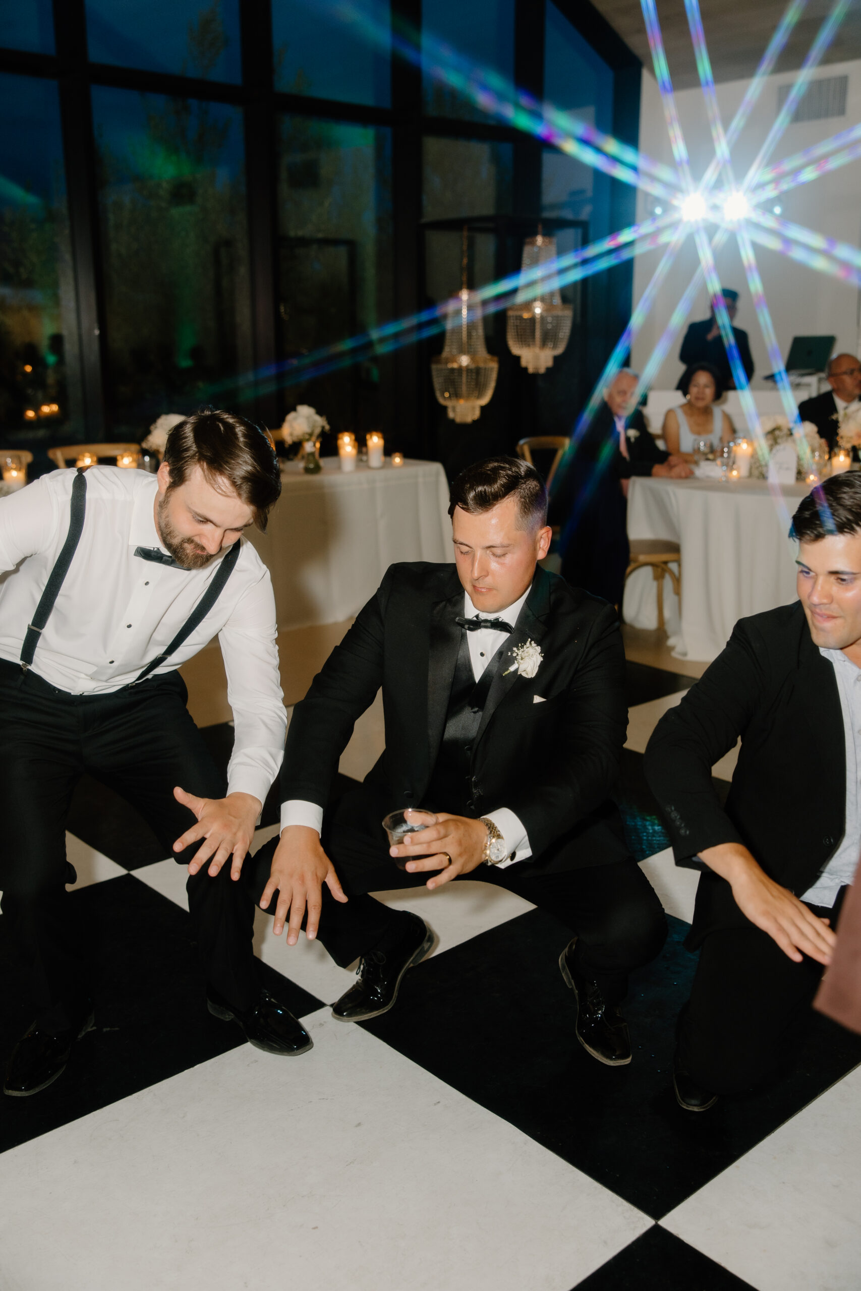 Groom and groomsmen dancing on the black and white checkered dance floor during the Desert View wedding reception.