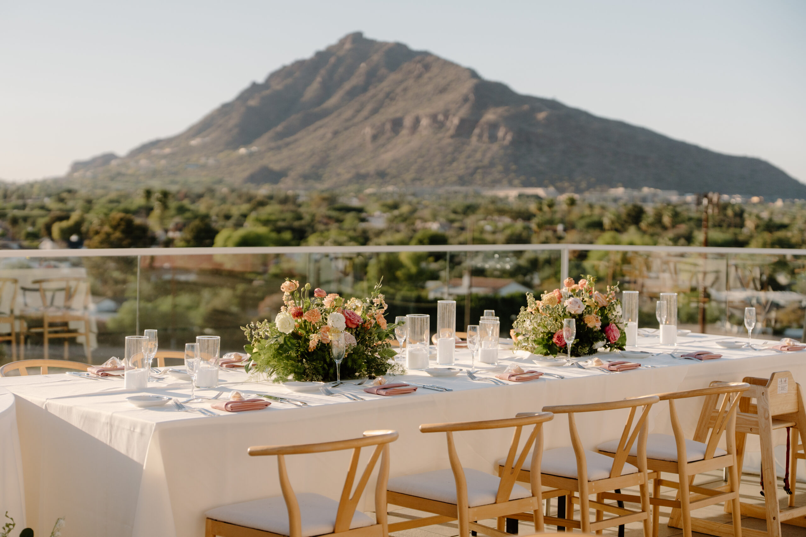 Reception table setup with floral centerpieces and mountain views in the background at Hotel Valley Ho