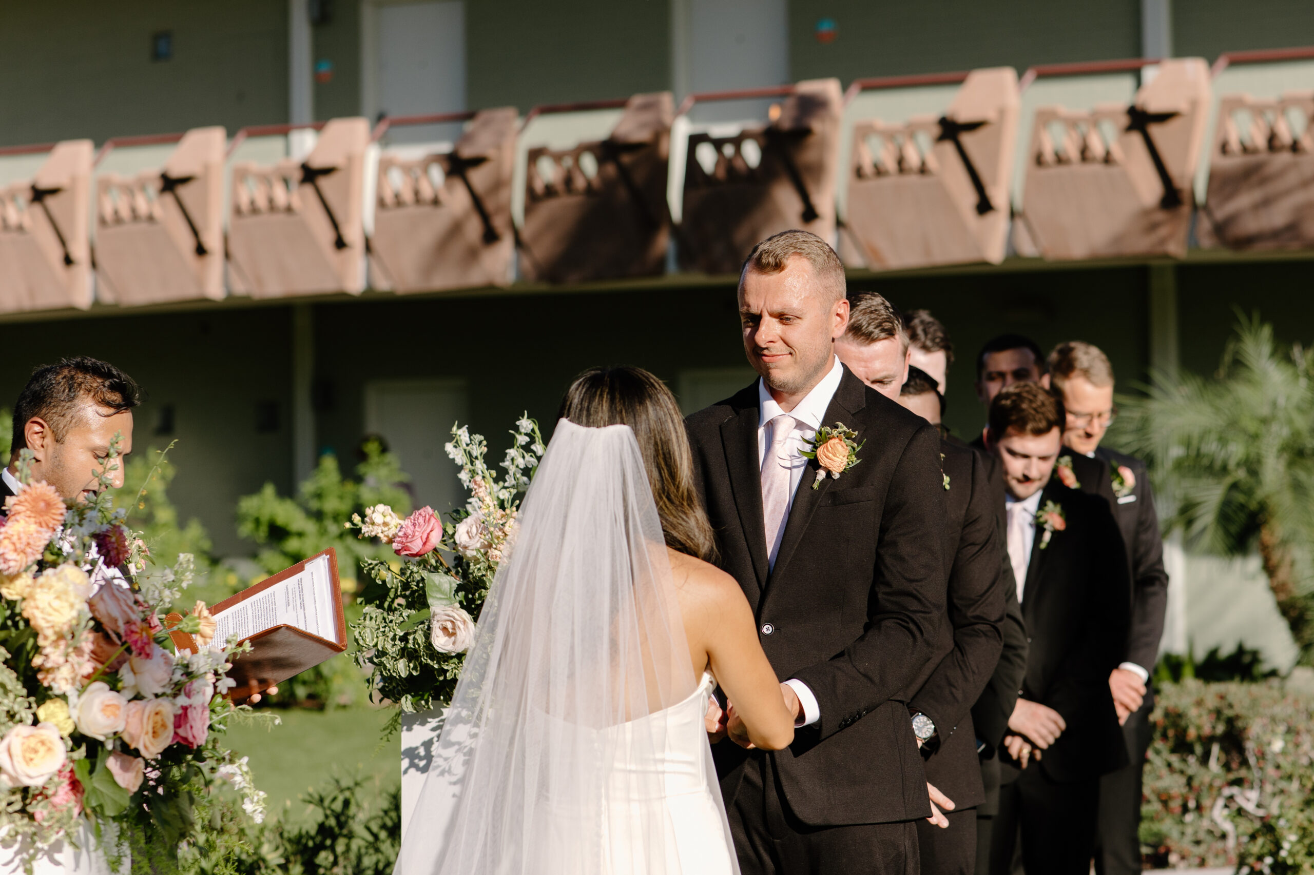 Bride and groom holding hands during their outdoor ceremony as they exchange vows at Hotel Valley Ho