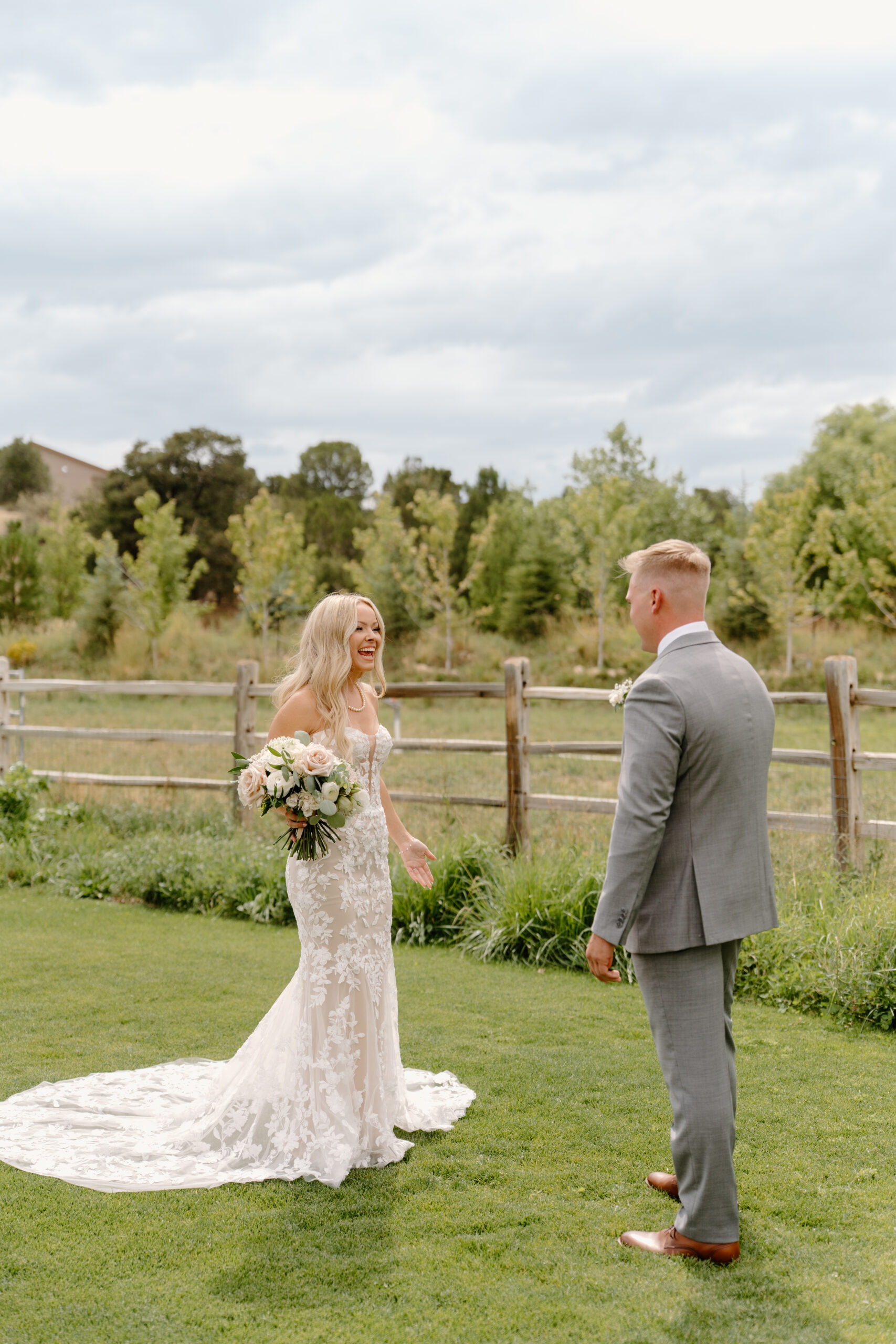 Joyful first look between bride and groom on the lawn before their wedding ceremony