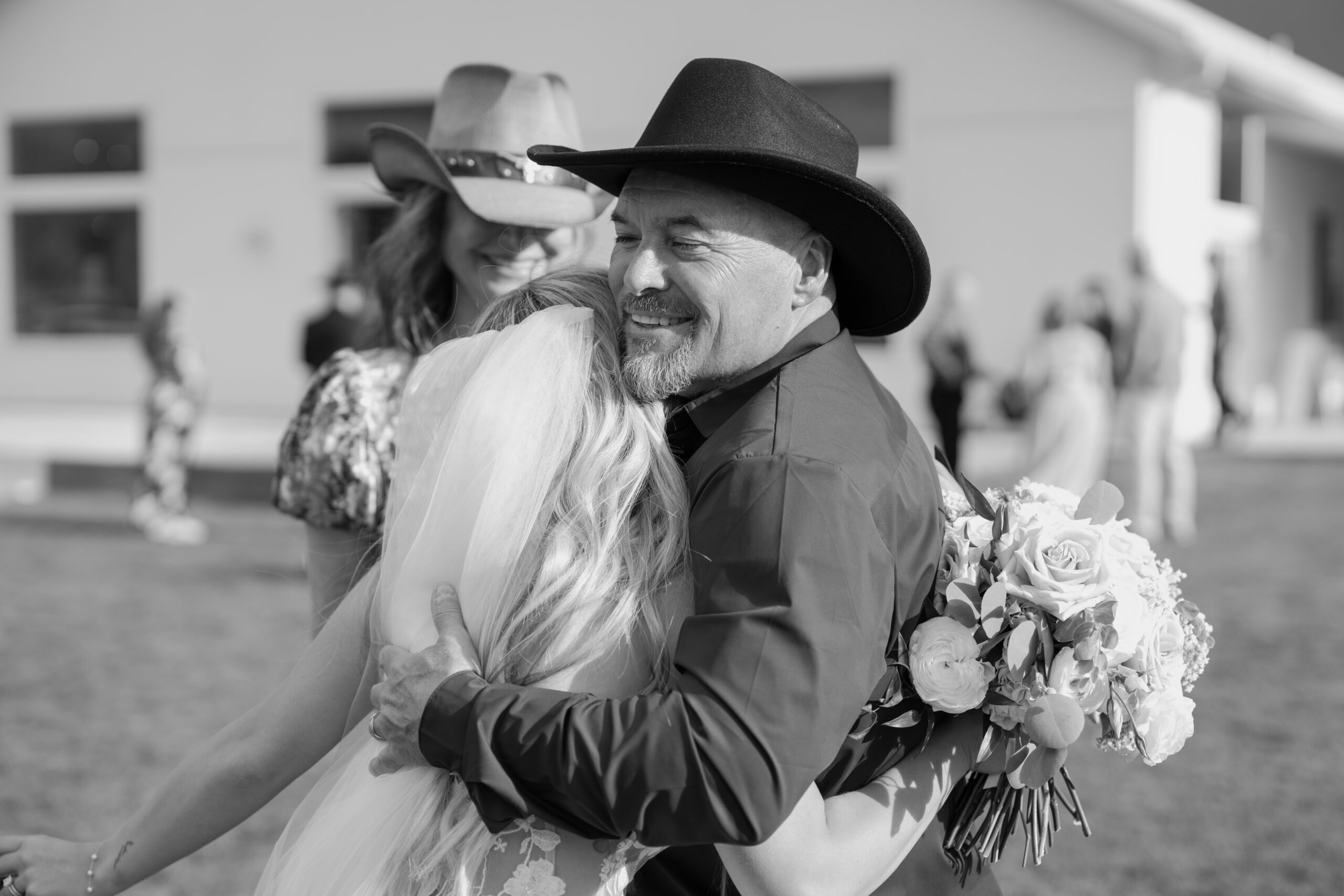 Emotional family hug during the wedding celebration captured in black and white