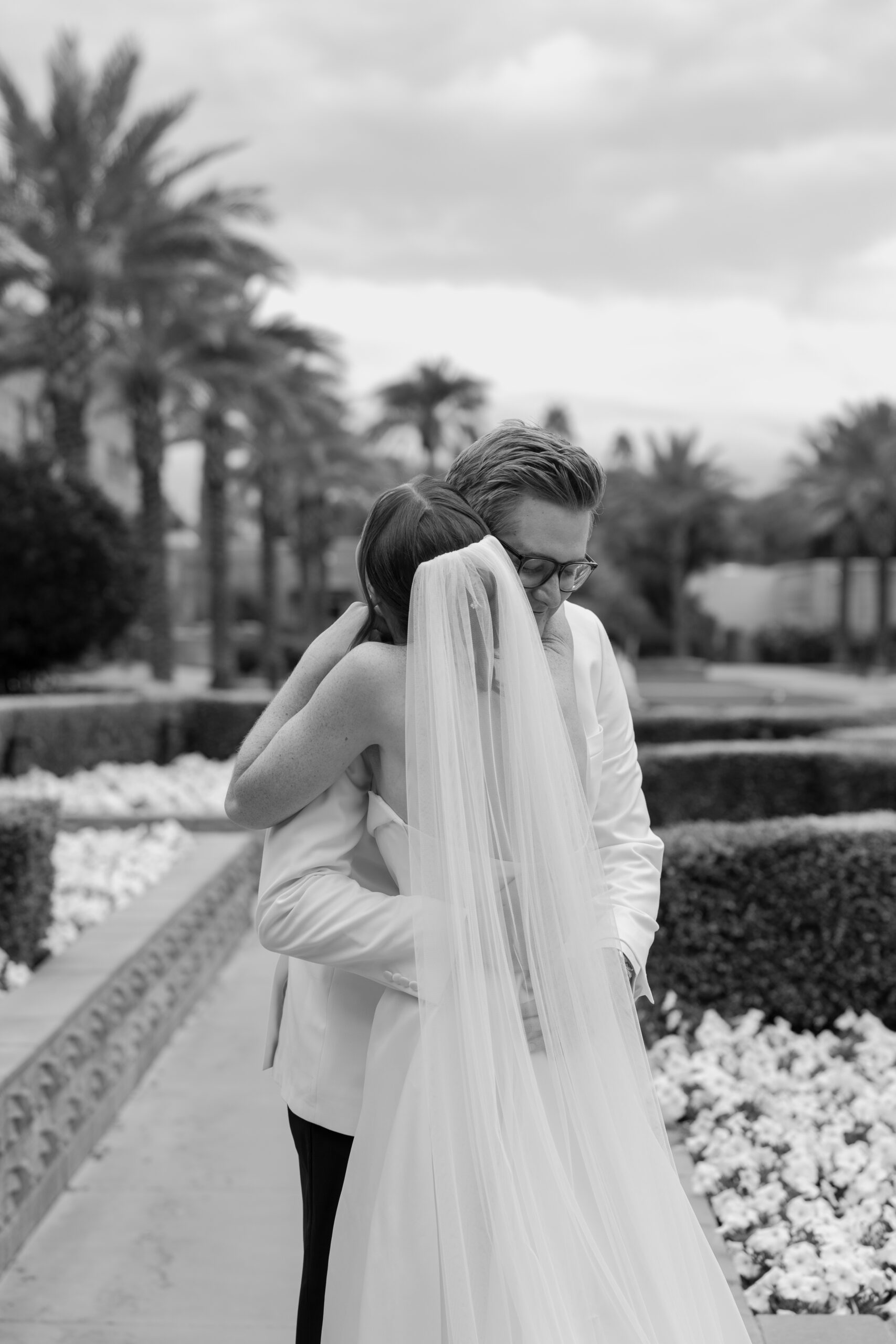 Black-and-white photo of the bride and groom embracing after seeing each other on their wedding day.