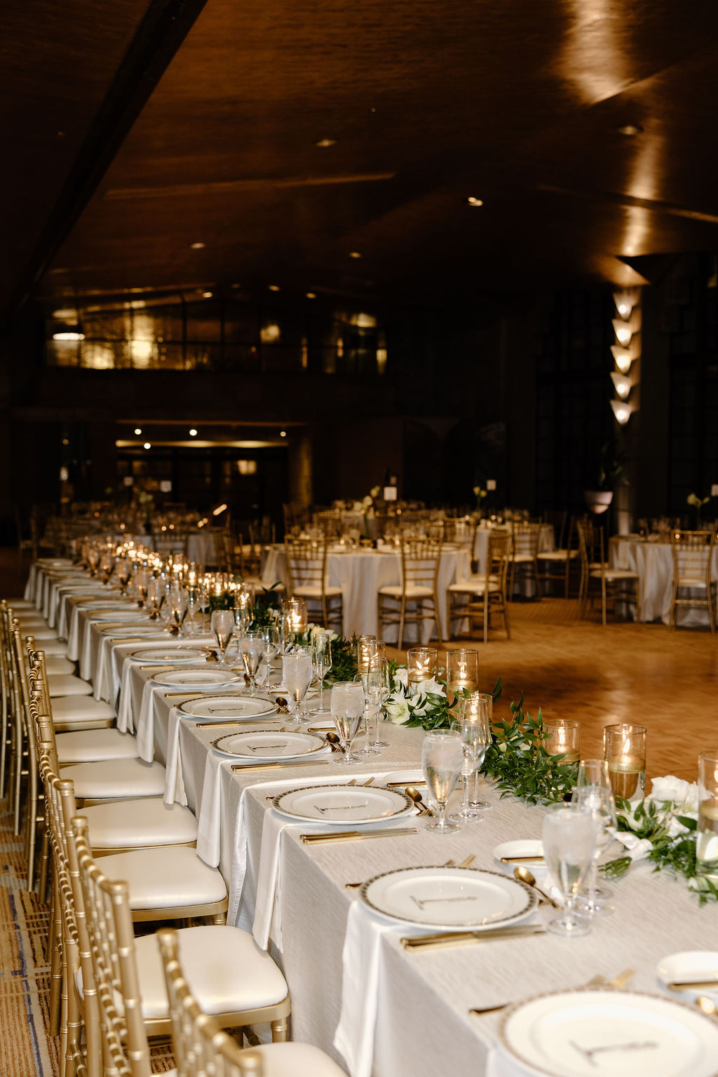Elegant Arizona Biltmore wedding reception with long tables, candlelight, white florals, and gold chairs.