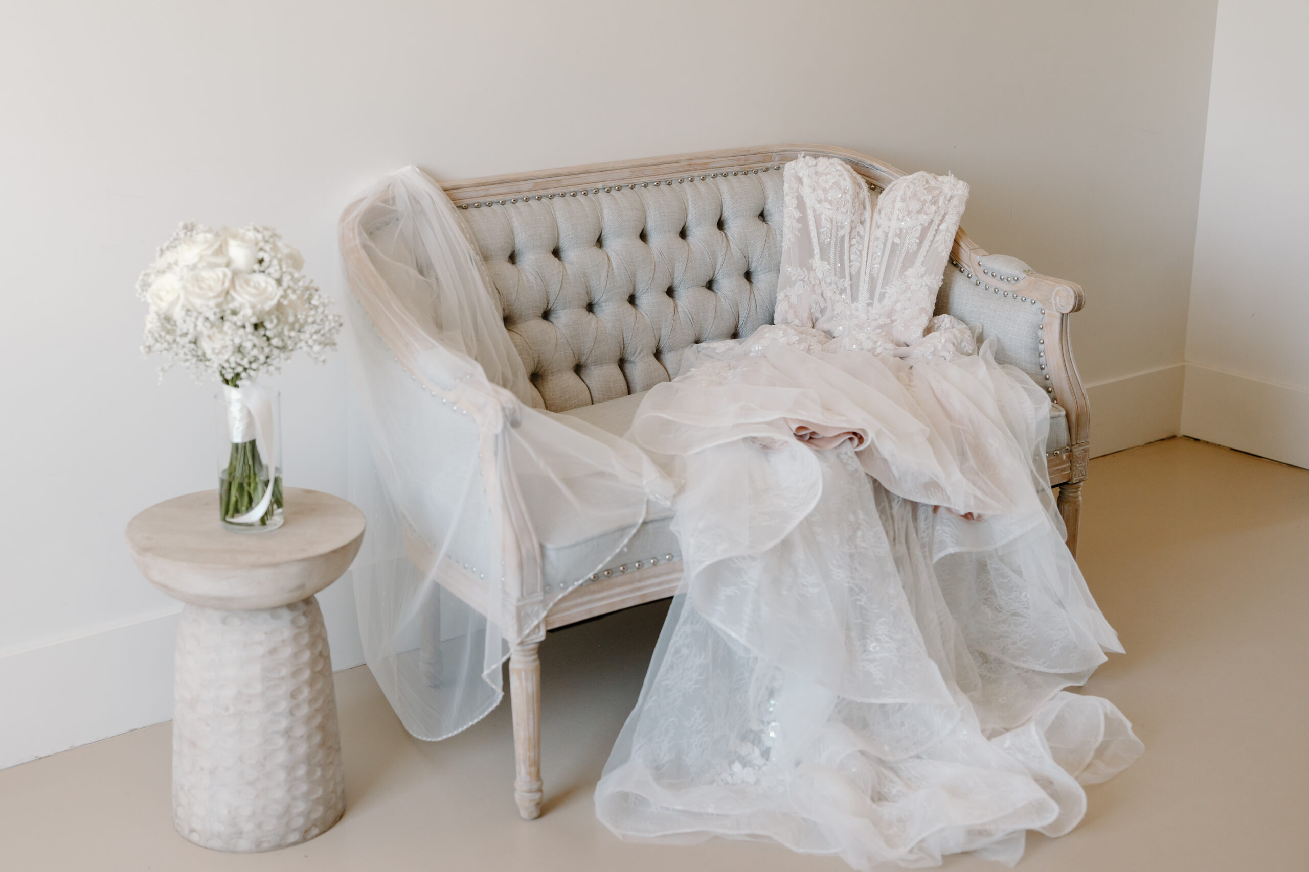 Wedding dress, veil, and white bridal bouquet styled together before the bride gets dressed, photographed by an Arizona wedding photographer.